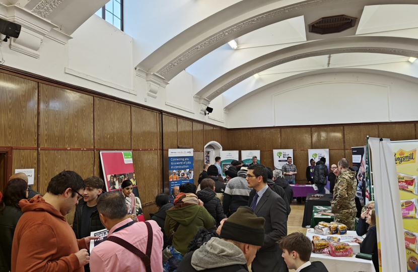 Busy room of people speaking to exhibitors at Jobs and Careers Fair